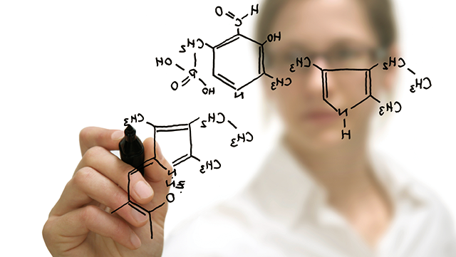 Frau schreibt Formel auf Glas