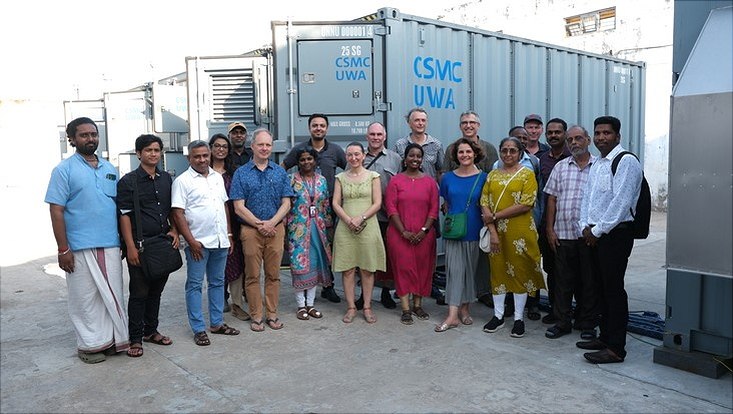 Gruppe von Mitarbeitern vor dem Container
