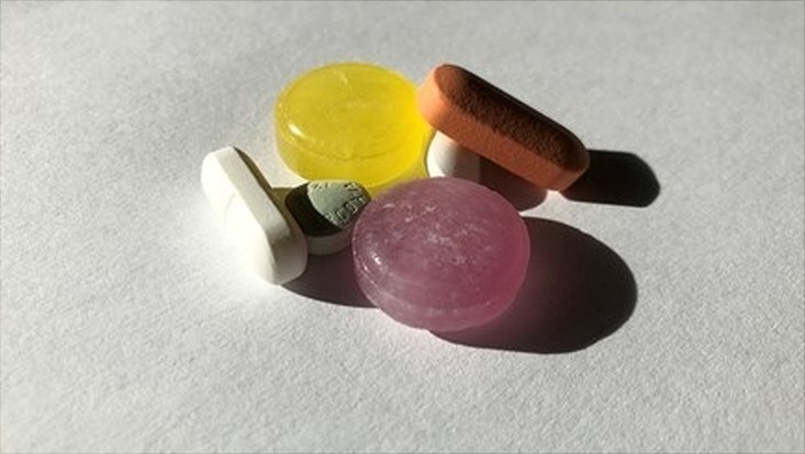 Tabletten in verschiedenen Farben und Formen auf einer hellen Fläche liegend